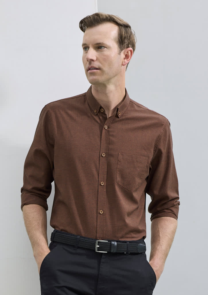 A brown long sleeve button-up shirt with a chest pocket and branding, worn with black trousers and a belt.