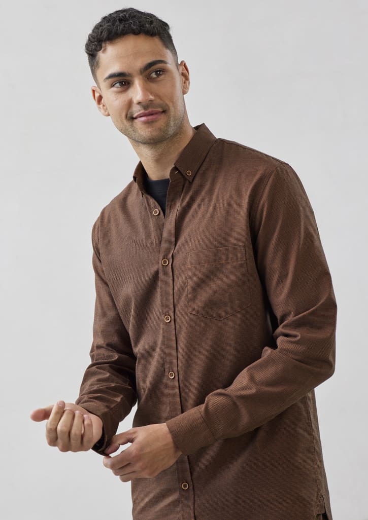 A brown long-sleeve button-up shirt with a single chest pocket and a logo. Styled on a model.