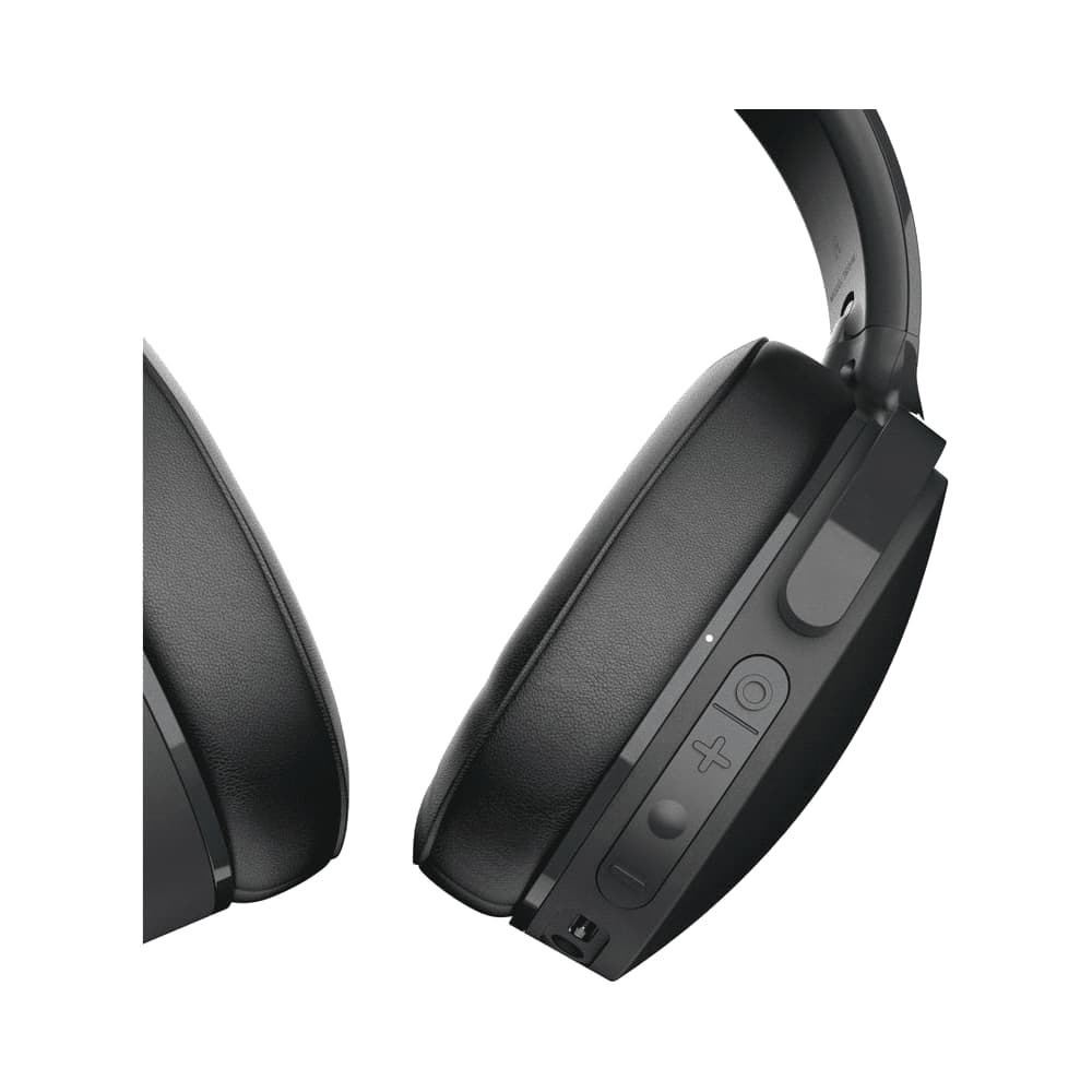 A pair of black Skullcandy Hesh ANC wireless headphones worn by a person with curly hair.