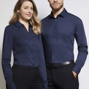 A pair of models wearing a navy blue women's long sleeve button-up shirt and a matching men's shirt, both with collars.