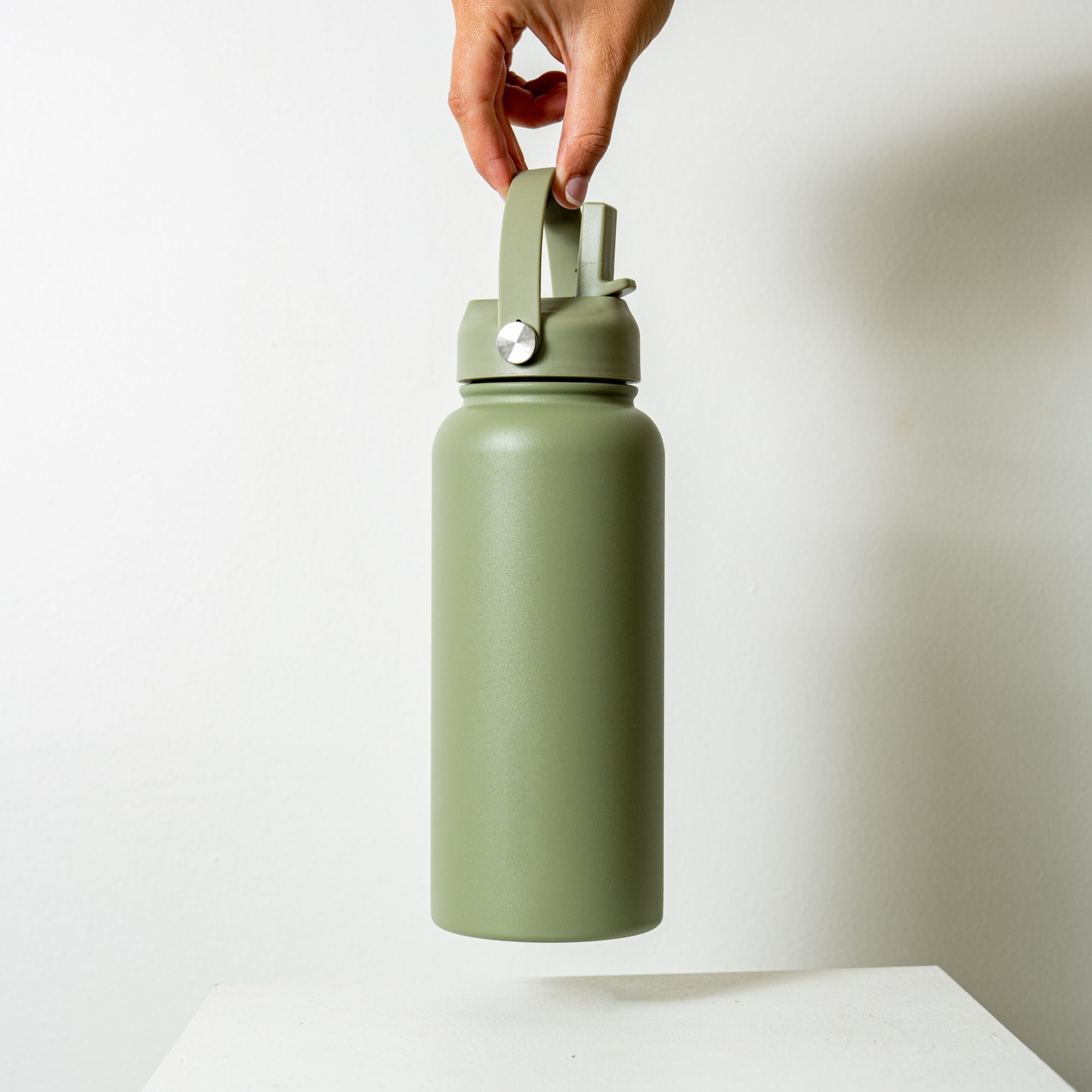A drink bottle in matte olive green, featuring a sturdy handle and a silver accent, with a logo displayed.