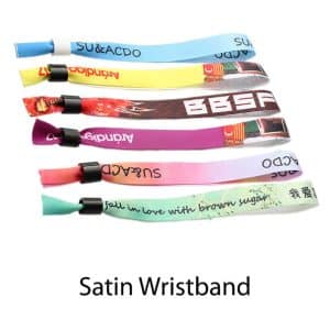A collection of satin wristbands in various colours, featuring different patterns and a logo on each band.