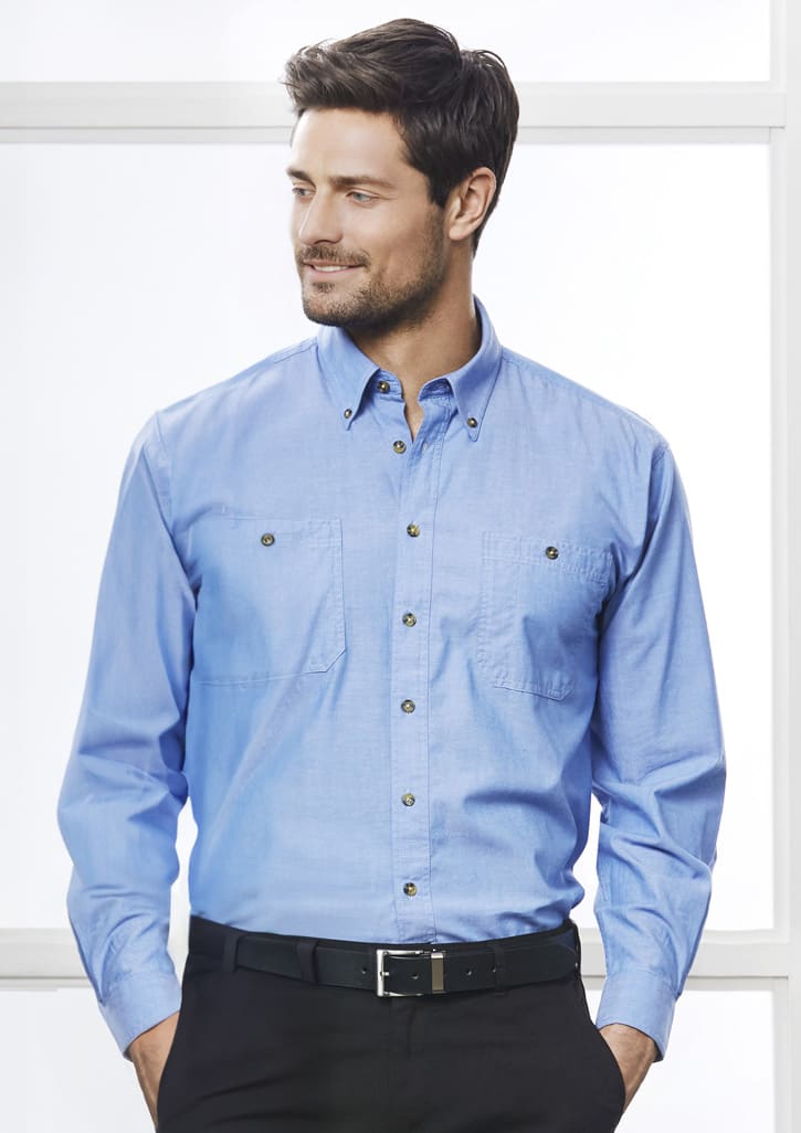 A men's long sleeve chambray shirt in light blue, featuring a button-up design and two front pockets.