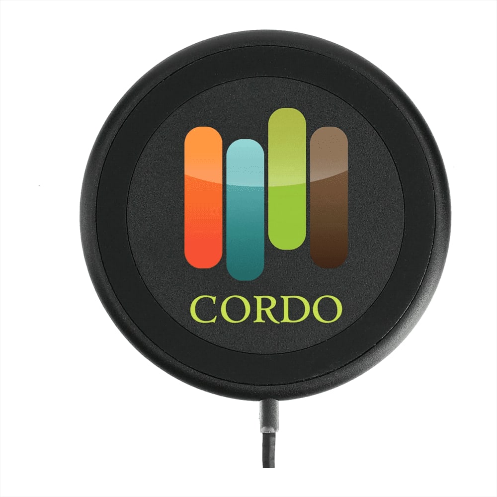 A round black wireless charging pad with a multicoloured logo and a charging cable attached.