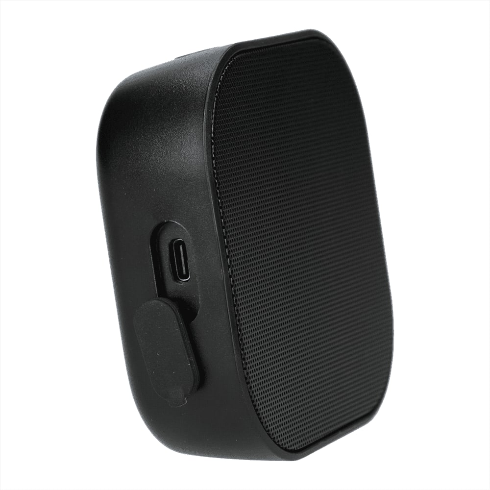 A black Bluetooth speaker with a textured front, featuring a charging port on the side and a logo on the surface.
