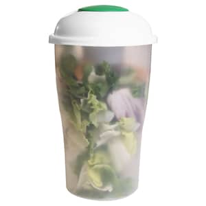 A transparent salad shaker with a green lid, containing mixed leafy greens inside. Features a logo.