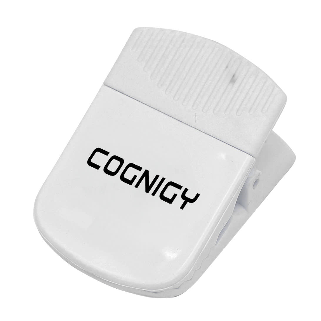 A white magnetic clip with a textured grip and a logo, designed for holding papers or other items.