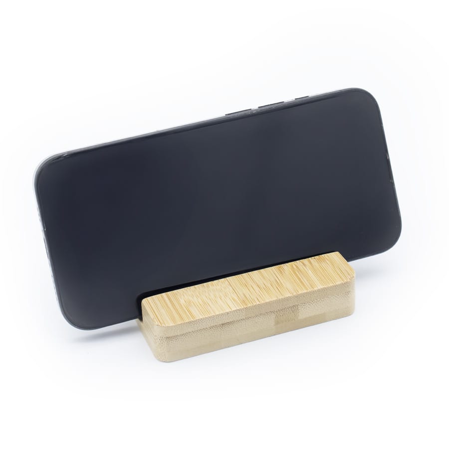 A bamboo phone stand holder with a black smartphone positioned upright on top. It features a simple, natural design.