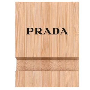 A bamboo phone holder in a natural wood finish featuring a logo on the front.