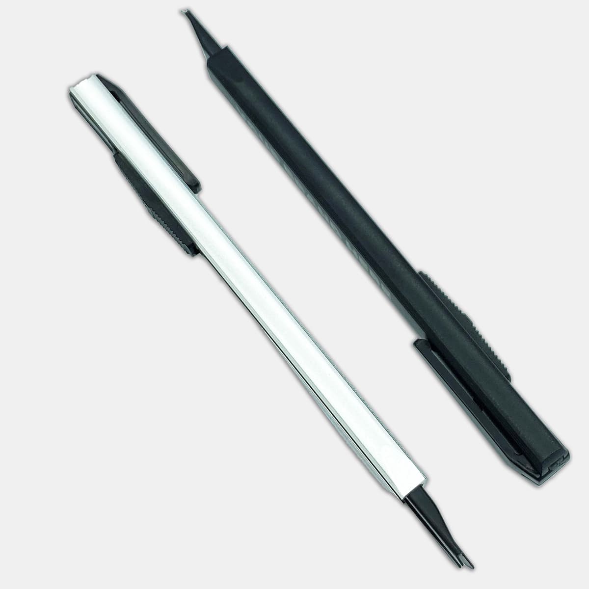 A slimline retractable box cutter in white and black, designed for ease of use, featuring a pocket clip and safety mechanism.