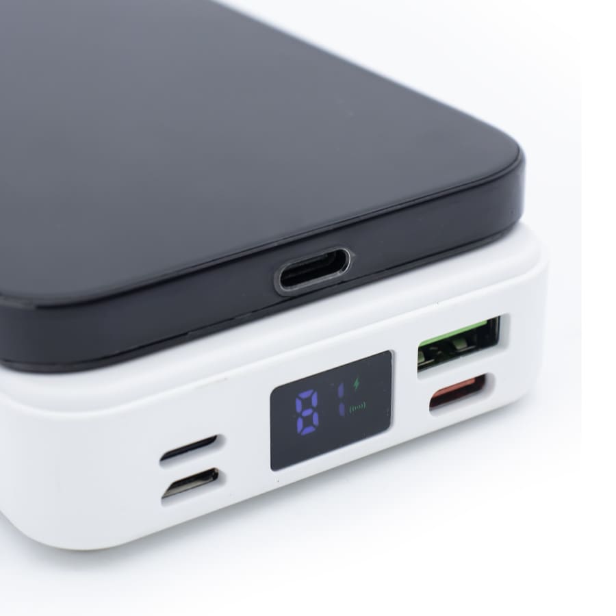 A black and white wireless charging power bank with multiple ports and a digital display.