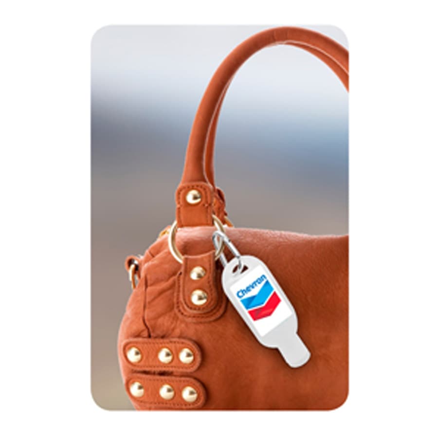 A brown handbag with gold studs and a carabiner attached, featuring a logo tag.