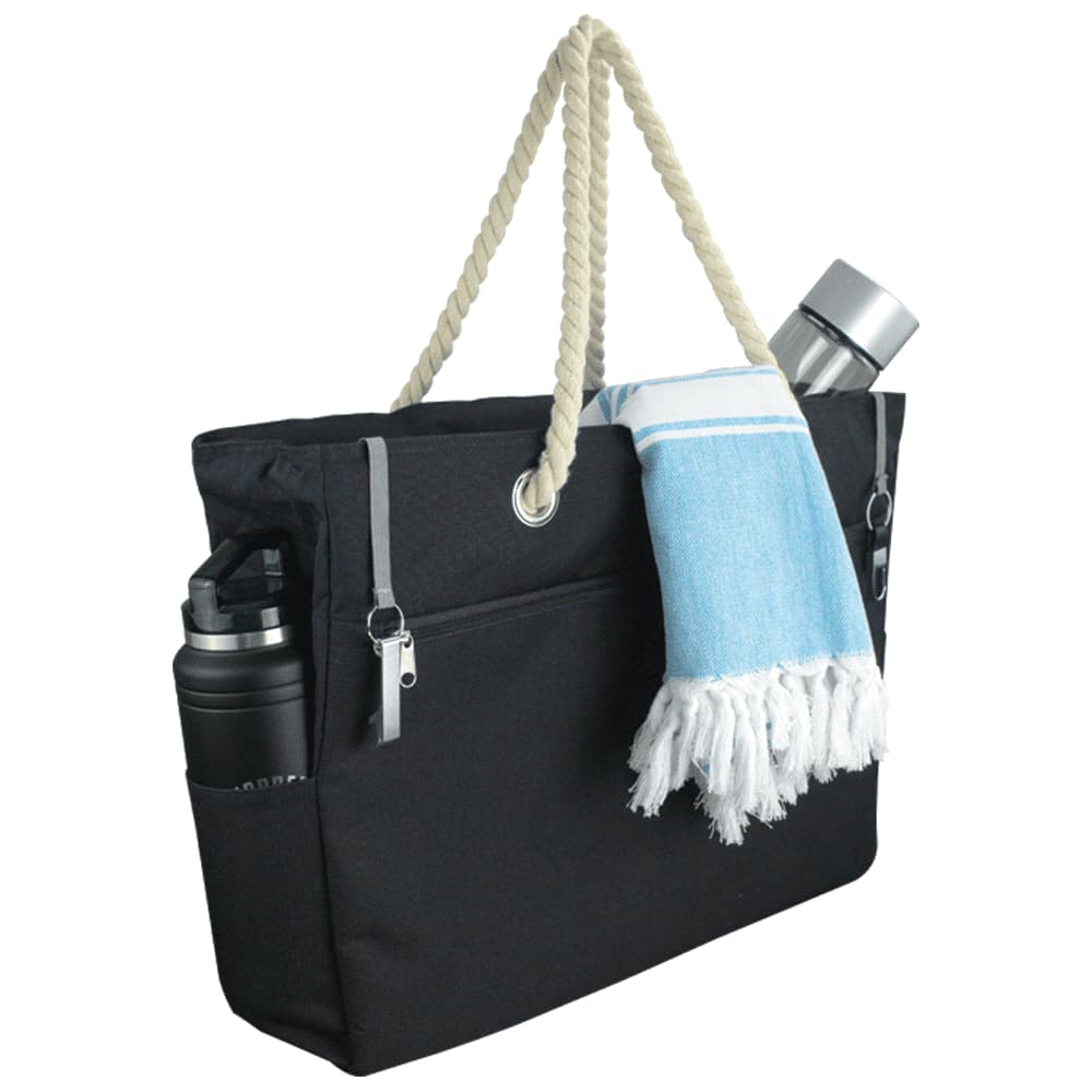 Navy waterproof beach bag with a rope handle and silver clasps, featuring two external pockets.