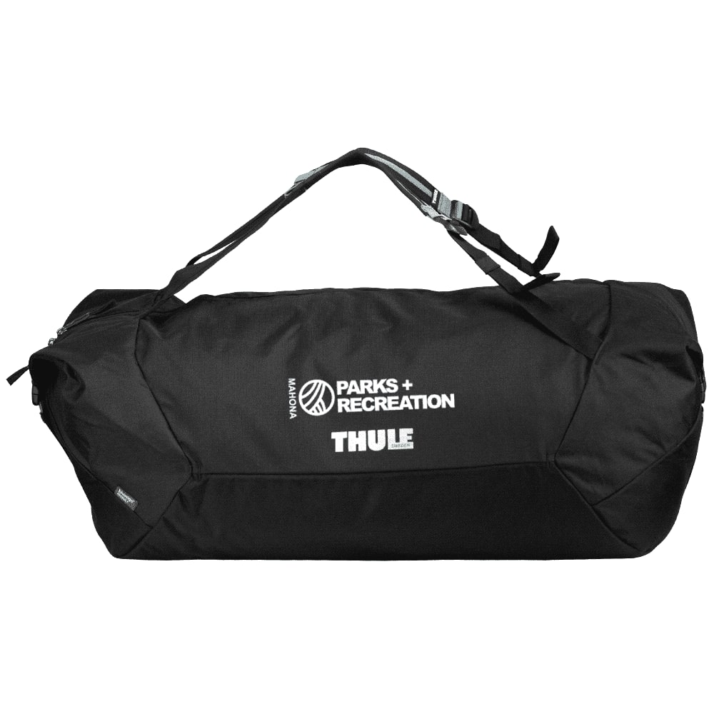 A black duffel bag with mid blue accents, featuring a logo, is being carried by a person from behind.