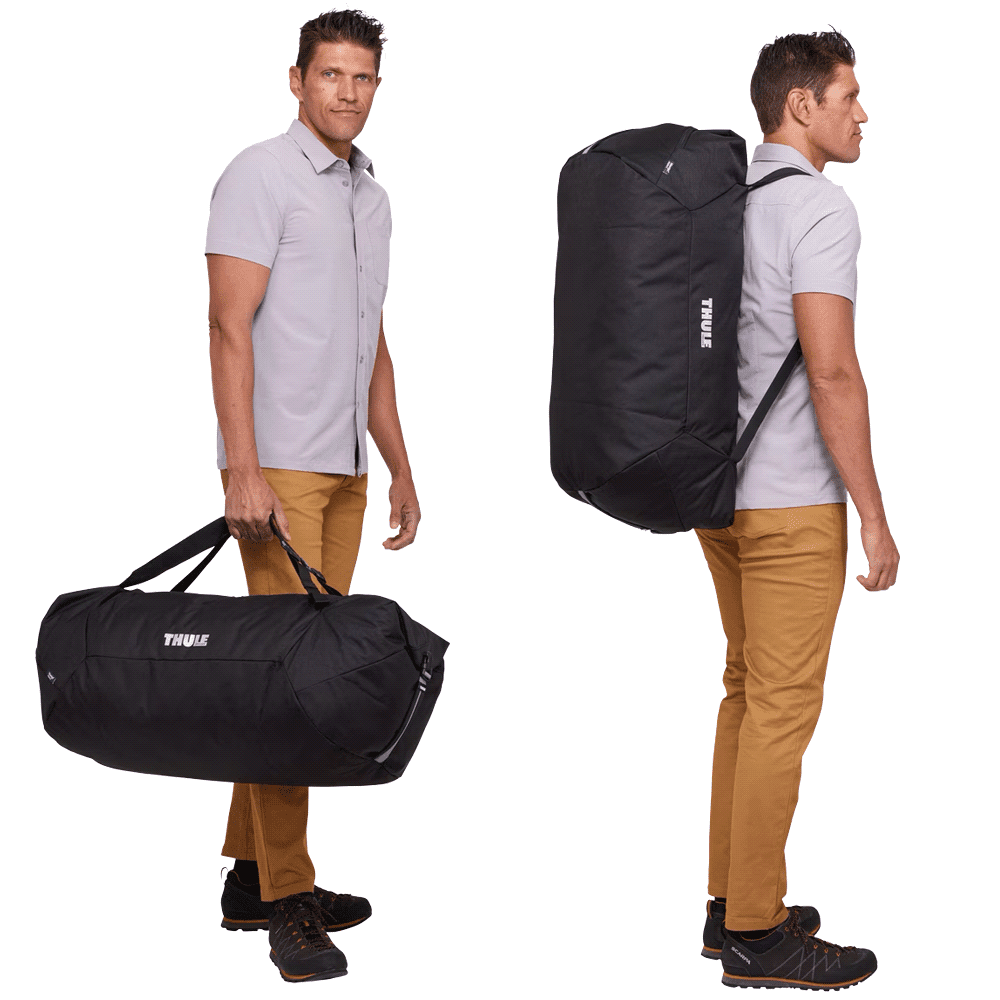 A black duffel bag with a mid blue accent and a logo, being held by a person.