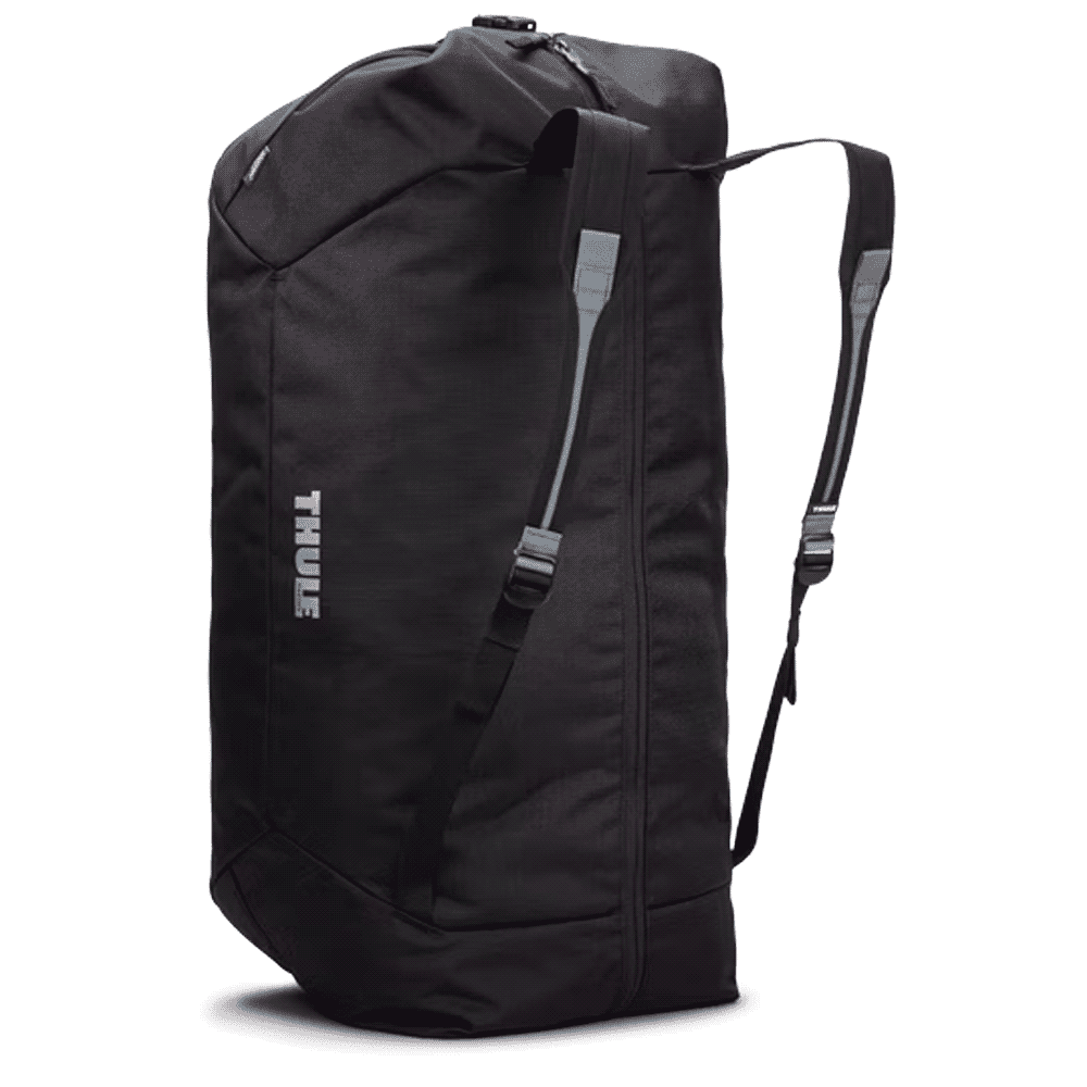 A duffel bag in black with a mid blue accent, featuring a shoulder strap and handles, held by a person.