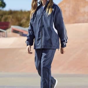 A girl walks wearing navy track pants with white stripes, paired with a matching jacket and sporty shoes.
