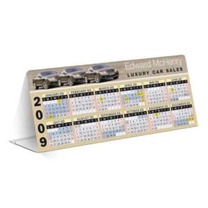 A table tent calendar featuring a car image, displaying the year 2009 with colourful monthly layouts. It has a logo.