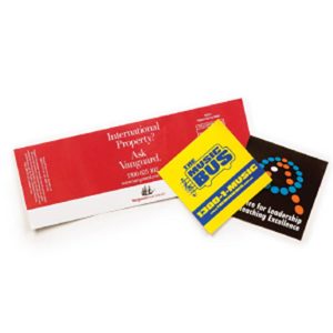 A collection of three vinyl stickers in various colours: red, yellow, and black, featuring logos and designs.