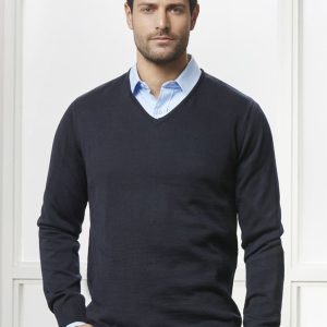 A navy blue pullover sweater with a V-neck, worn over a light blue shirt. The model stands against a bright background.