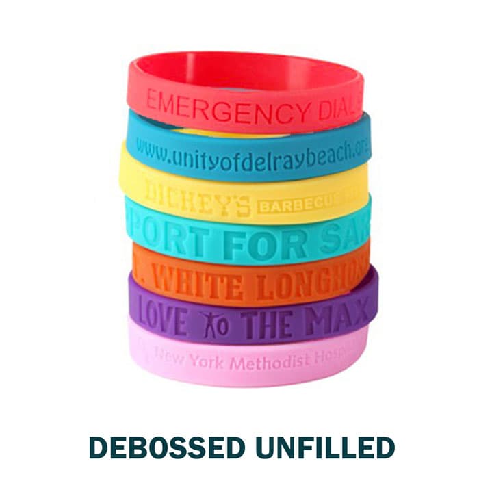 A stack of silicone wristbands in various colours, featuring different embossed text and a logo on one band.