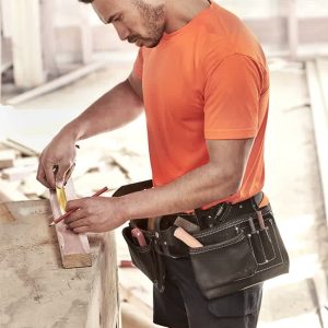 A men's high visibility t-shirt in bright orange, worn by a tradesman measuring wood, with a tool belt.