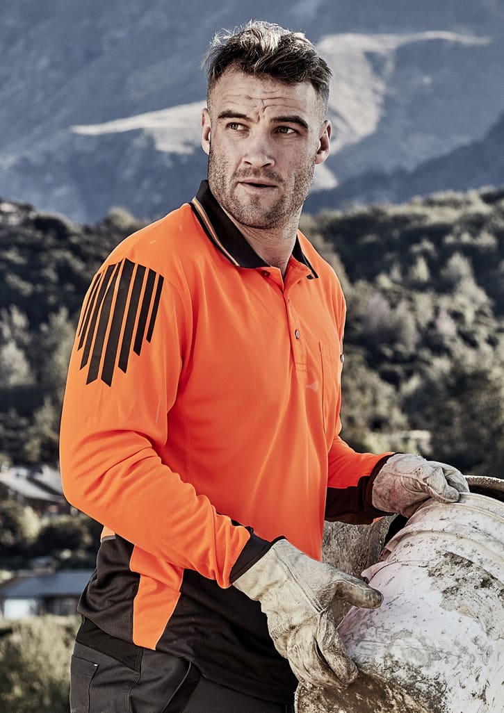 A long sleeve polo in high visibility orange and black, featuring a logo and worn by a man outdoors.