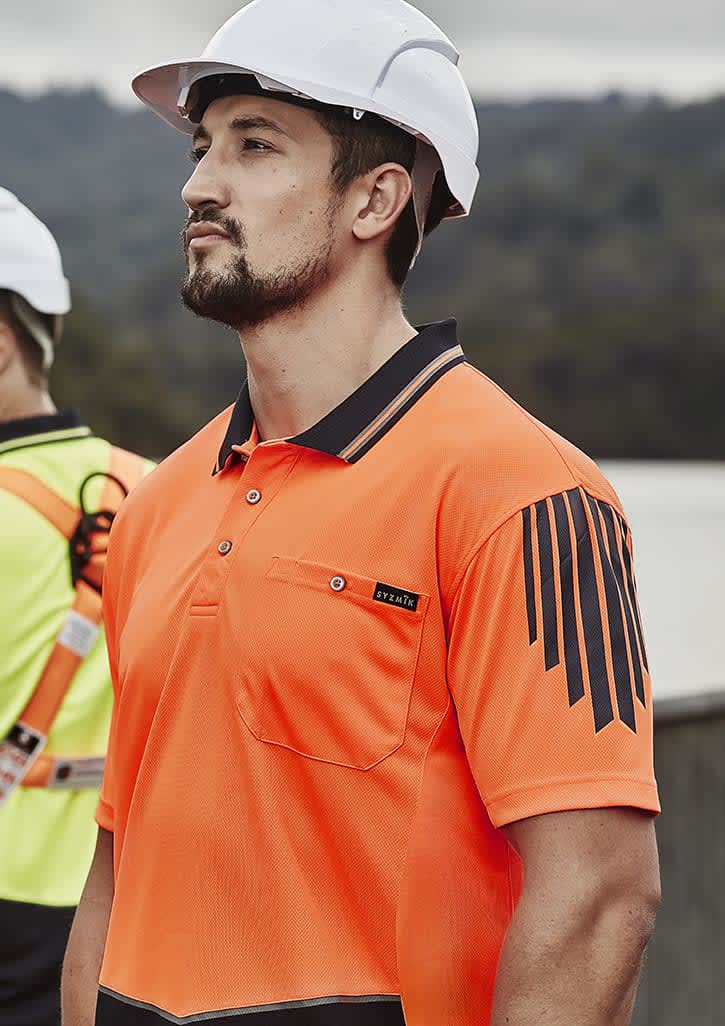 An orange short sleeve polo shirt featuring a logo and black striped design, worn by a man in a hard hat.