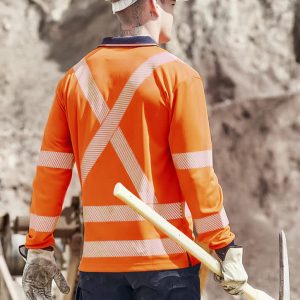 A long sleeve polo shirt in hi-vis orange with reflective stripes, worn by a worker on a construction site.