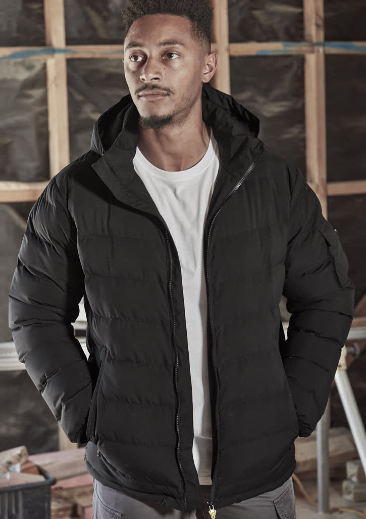 A black unisex hooded puffer jacket with a zip front, worn by a model in a construction setting.