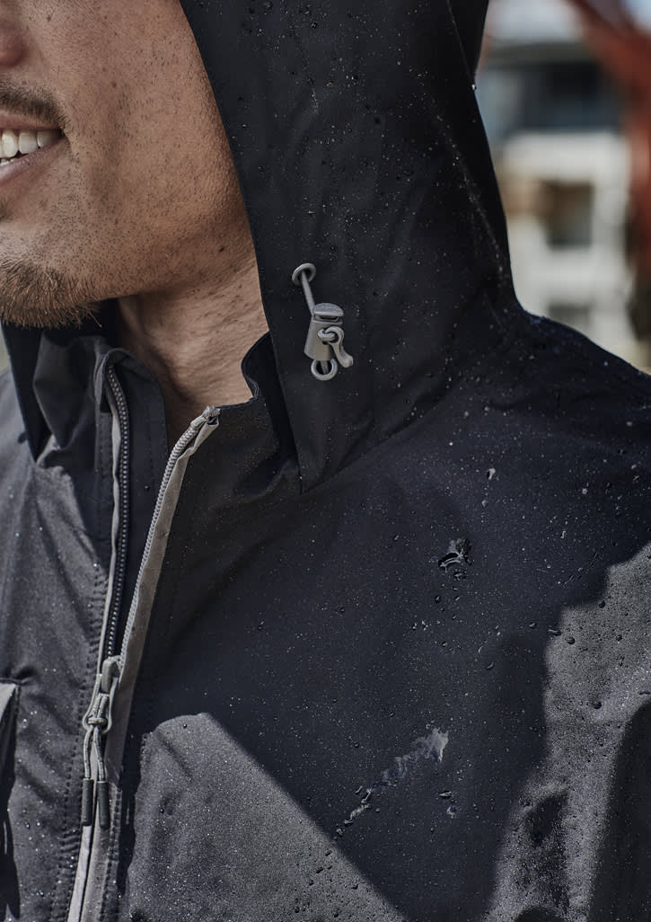 A black unisex packable rain jacket with a hood, featuring water droplets on its surface and a logo detail.