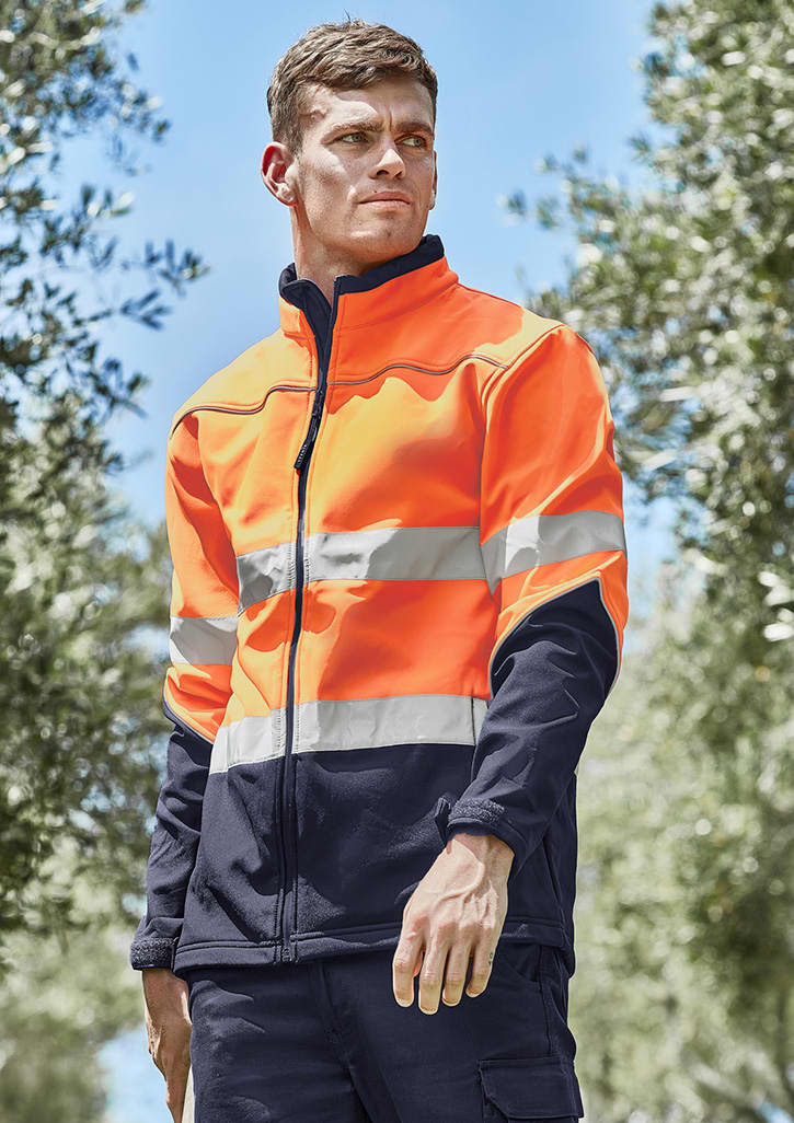 A hi-vis softshell jacket in bright orange and navy, featuring reflective stripes and a zipped front, worn by a model outdoors.