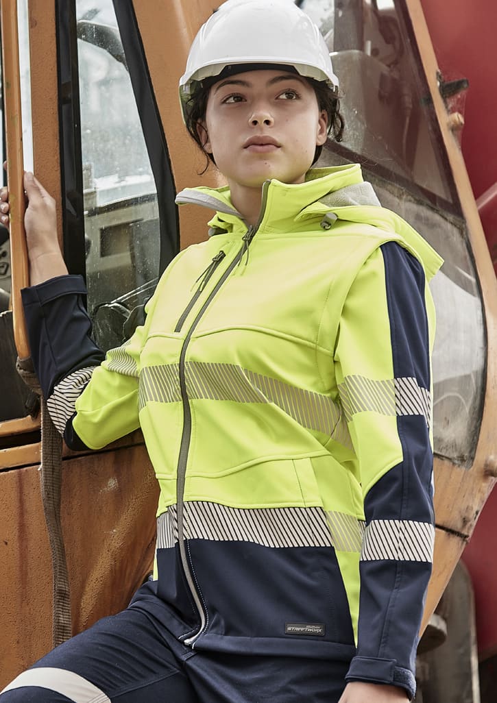 A women's softshell jacket in hi-vis yellow and navy blue, featuring reflective stripes and a hood. It has a logo on the front.