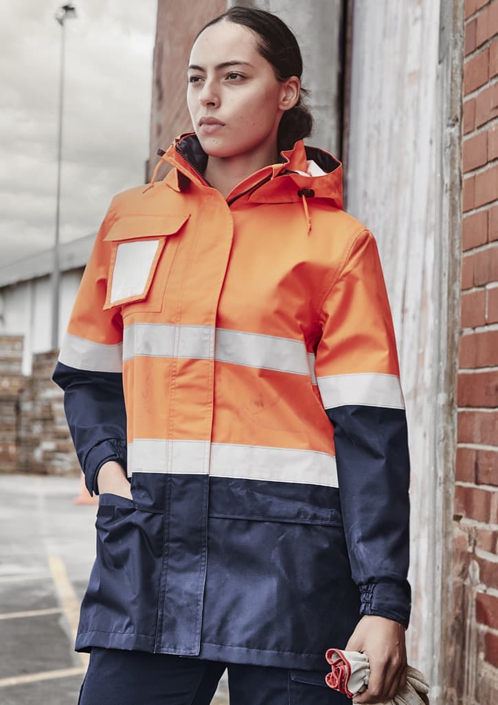 A women's hi-vis ultralite waterproof jacket in orange and navy, featuring reflective stripes and a hood.
