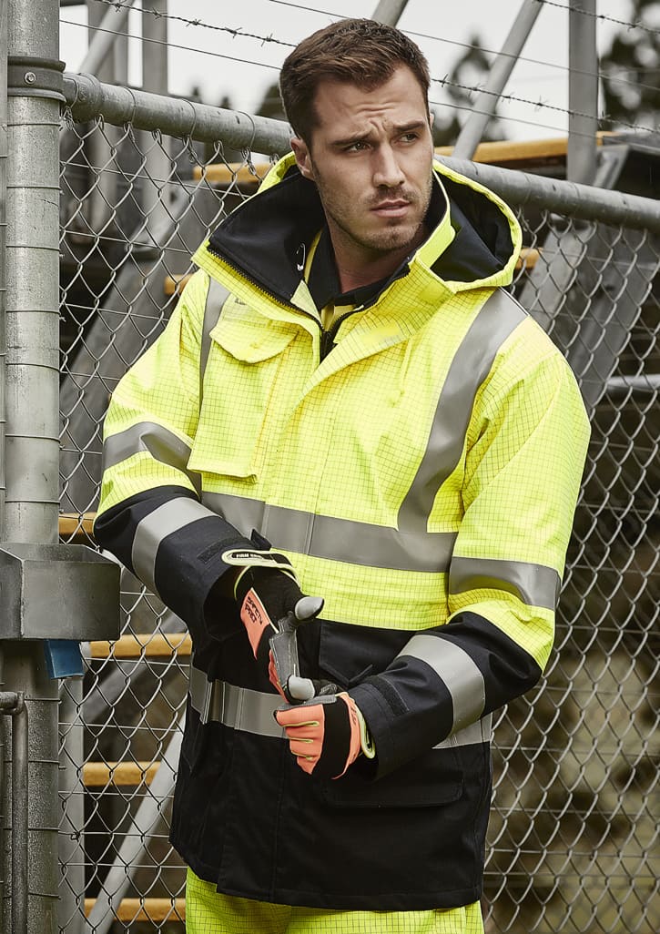 A men's waterproof jacket in bright yellow and black, featuring reflective stripes and a logo, worn by a man.