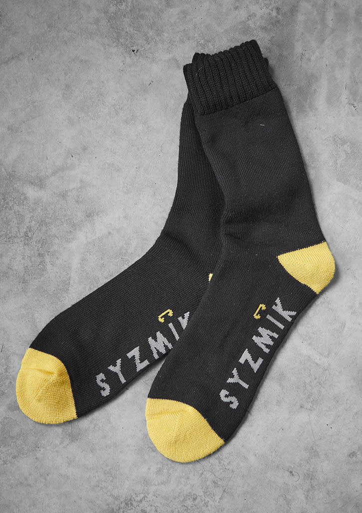 A pair of black bamboo work socks with yellow toes and a logo. They are part of a three-pack.