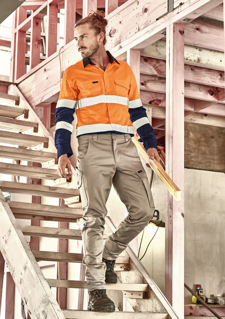 Men's essential basic stretch cargo pants in beige, featured with a logo, paired with an orange and navy work shirt.