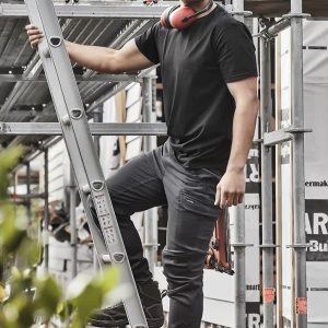 Men's Streetworx Comfort Pant in black, featuring pockets and a branded logo, worn by a man on a ladder at a worksite.