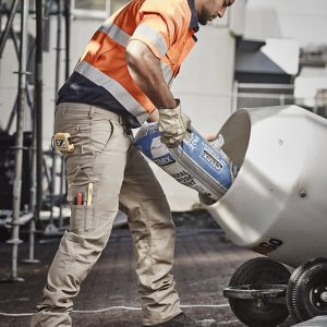 Men’s cargo pants in beige, featuring multiple pockets, worn by a worker pouring materials into a mixer.