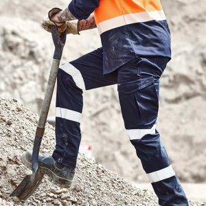 Mens Essential Stretch Taped Cargo Pant in navy blue with reflective stripes, worn by a person shovelling gravel.