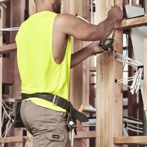 Men's summer cargo shorts in khaki, featuring multiple pockets, worn by a person in a bright yellow sleeveless top.
