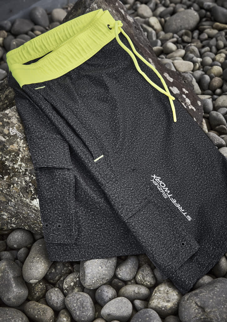 A pair of black sports shorts with a neon yellow waistband and drawstring, featuring a logo.