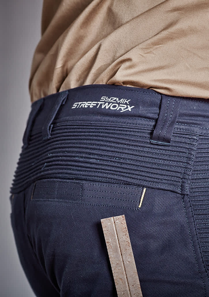 A close-up of navy shorts featuring a branded waistband and a ruler for measuring, highlighting the fabric's texture.