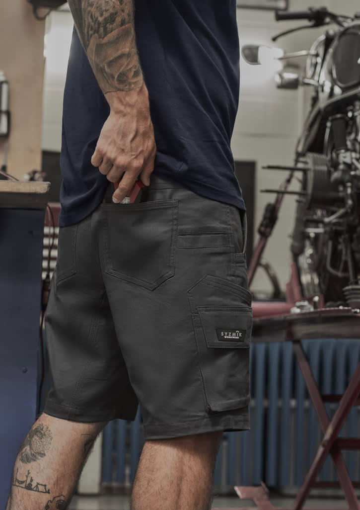 Men's rugged shorts in dark grey with utility pockets, featuring a logo on the side and a fitted design.