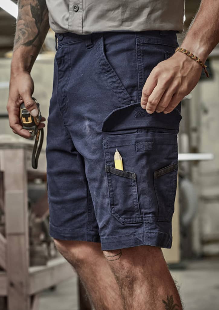 Work shorts in navy blue with multiple pockets and a pencil visible in the side pocket. Features a logo.