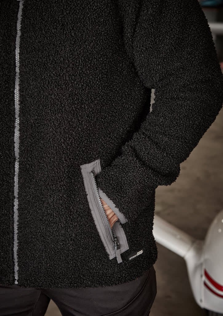 A black unisex full zip sherpa fleece jumper with side pockets and a logo.