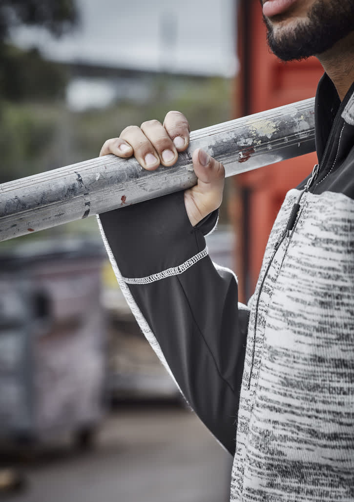 A person holding a metal pole wears a grey and black reinforced knit hoodie with a logo.