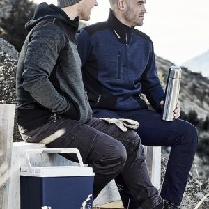 Two men seated outdoors, one wearing a grey reinforced knit hoodie and the other in a navy pullover, holding a drink bottle.