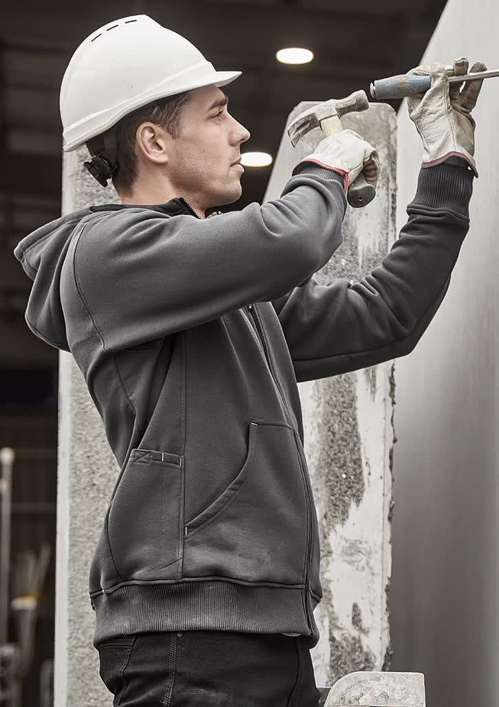 A grey unisex zip front multi-pocket hoodie worn by a worker using a tool, with a safety helmet and gloves.