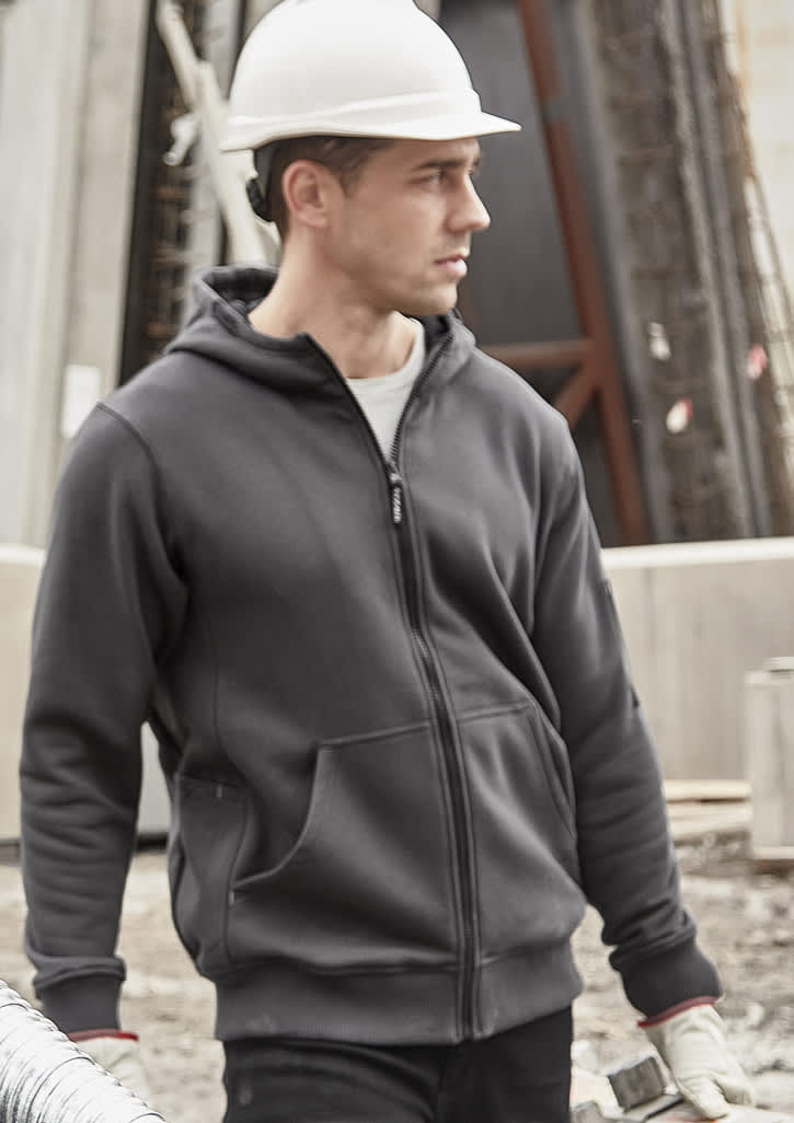 A unisex zip front multi-pocket hoodie in dark grey, featuring a hood and a logo, worn by a model at a construction site.